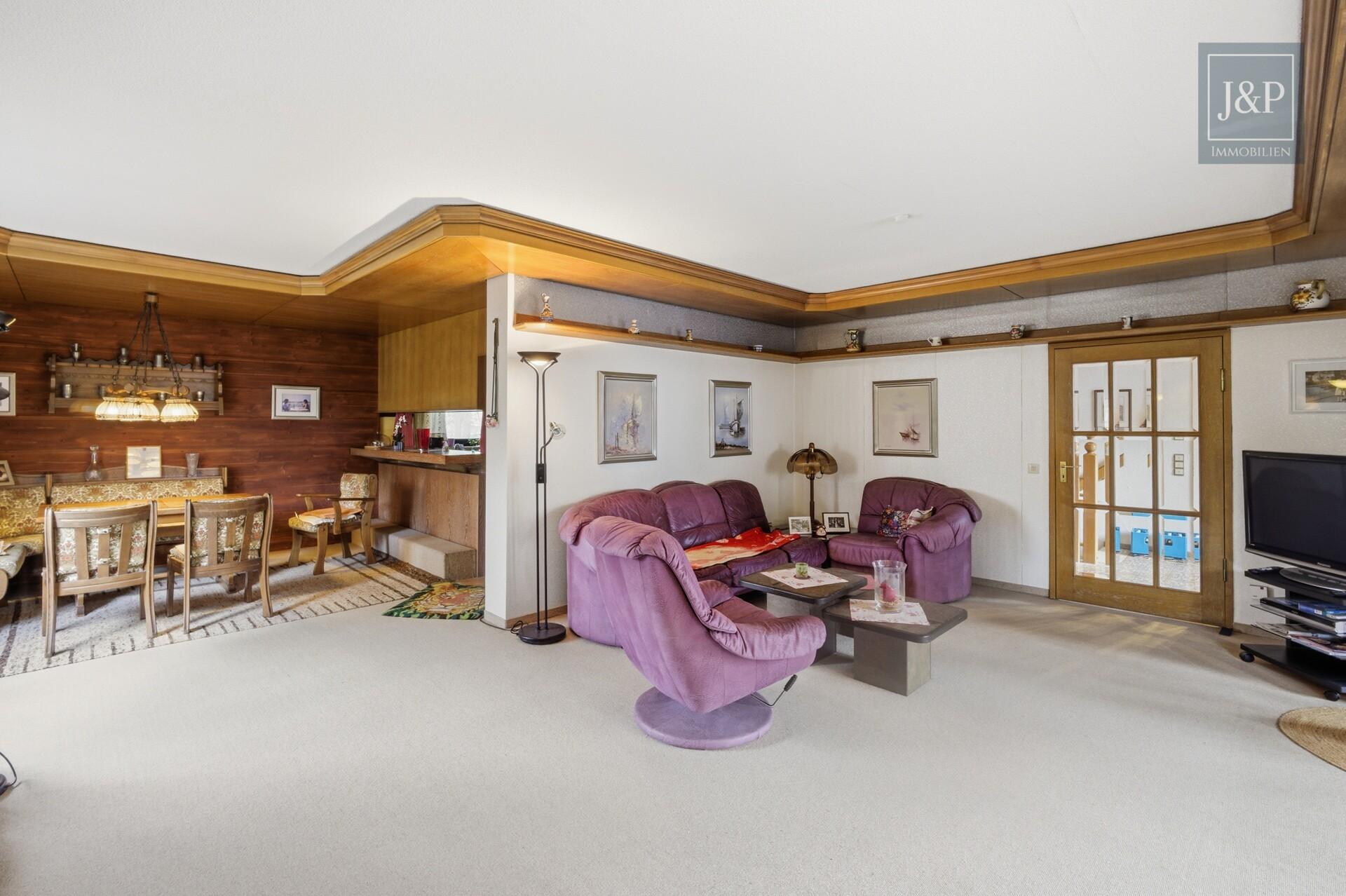 Zeitlose Eleganz der 70er: weitläufiger Bungalow mit Wintergarten-Oase und offenem Kamin - Wohn-Ess-Bereich